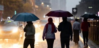 “People walking through waterlogged streets in India as the IMD issues a heavy rainfall alert across 18 states.
