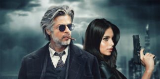 Shah Rukh Khan in a stylish black suit with fiery background, representing King teaser record views
