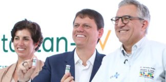 scientists at Brazil’s Butantan Institute holding a vial of the newly approved single-dose dengue vaccine.