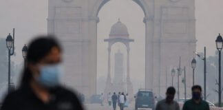 Masked commuters walk through thick haze near India Gate as AQI crosses 300