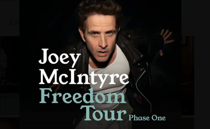 “Joey McIntyre performing live on stage under festive lights at Tinselcolor: Holiday Soundtracks LIVE in Los Angeles.”