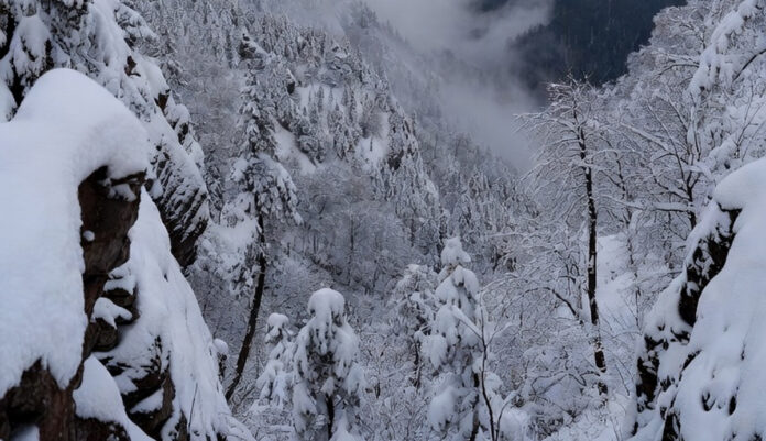 Snow-covered Himalayan mountains and foggy plains as India faces a severe cold wave during early December 2025