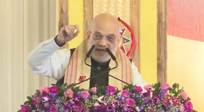 amit-shah-assam-infiltratio Union Home Minister Amit Shah addresses a public rally in Assam ahead of assembly elections.