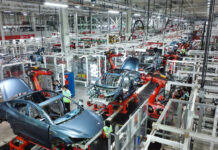 Dozens of Chinese EV Makers Face Shutdown Risks in 2026 Amid Overcapacity Crisis Modern assembly line in a Chinese electric vehicle factory producing multiple EV models