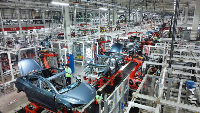 Modern assembly line in a Chinese electric vehicle factory producing multiple EV models