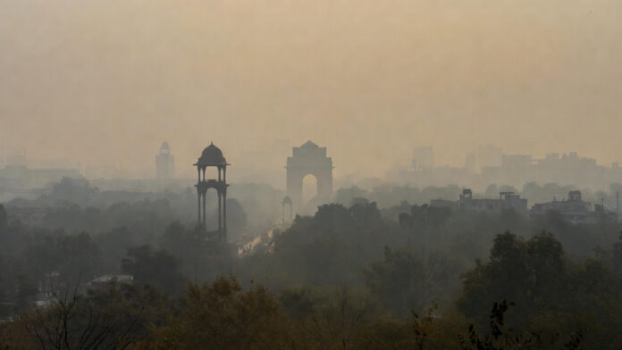 Thick smog shrouding Delhi skyline with India Gate faintly visible on hazy New Year's morning 2026