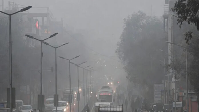 delhi-truck-entry-ban-sever Smog-covered Delhi highway with trucks halted following non-essential entry ban due to severe air pollution.
