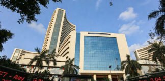 NSE building in Mumbai with stock market screens displaying trading and settlement holiday notice