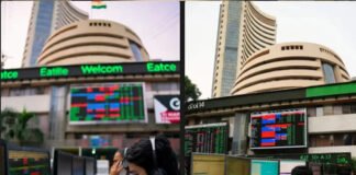Stock market traders watch falling Sensex numbers on display screens in Mumbai