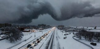 Massive winter storm in the United States with heavy snow covering highways and disrupted airport operations