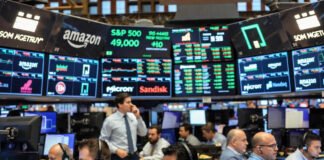 Wall Street stock market trading floor and closing bell with rising index screens