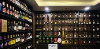 Liquor bottles displayed at a Delhi store as excise license fees increase by 10% for 2026–27