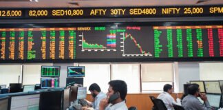 Traders monitoring live Sensex and Nifty market data on digital screens at the Bombay Stock Exchange in Mumbai