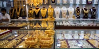 Gold and silver prices decline amid global economic pressures and strong dollar.