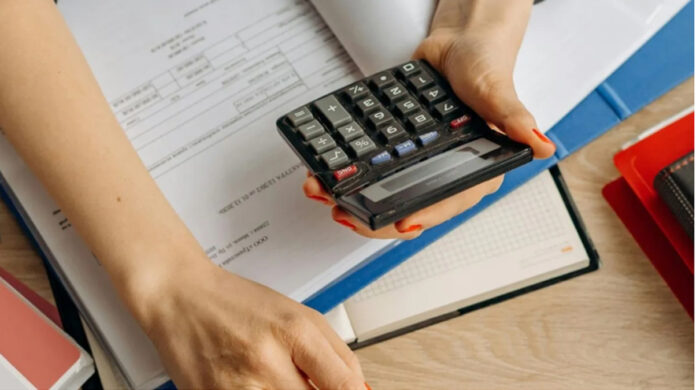 compound-interest-calculato Person using compound interest calculator on laptop to calculate personal loan EMI and interest