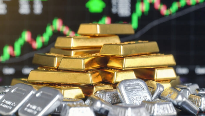 gold-silver-price-surge-ira A close-up of gold bars and stacked silver bullion with a digital trading screen in the background showing rising price charts, symbolizing the sharp rally in precious metals.