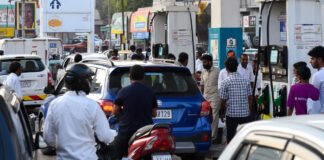 Petrol pump in India showing increased fuel prices with customers refueling vehicles
