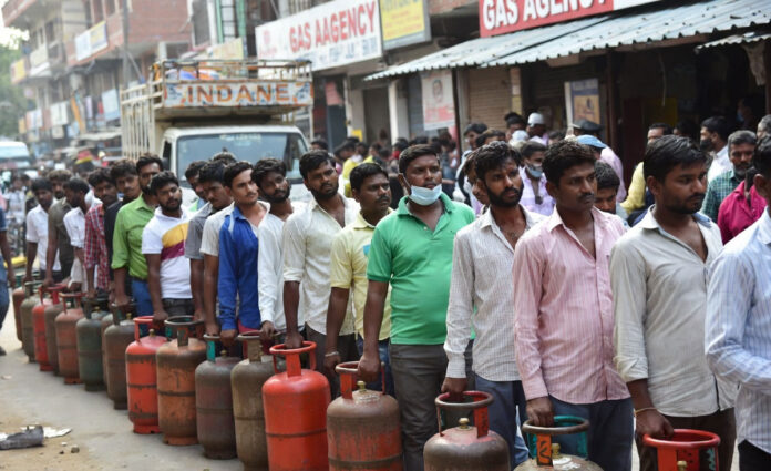 lpg-cylinder-price-hike-ind People waiting in line for LPG gas cylinders amid shortage and price hike concerns in India
