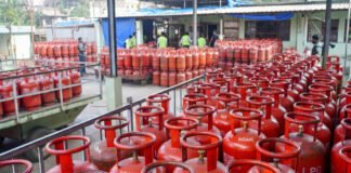 LPG cylinder price hike in India March 2026 domestic cooking gas cylinder and commercial LPG cylinders stacked at distribution center