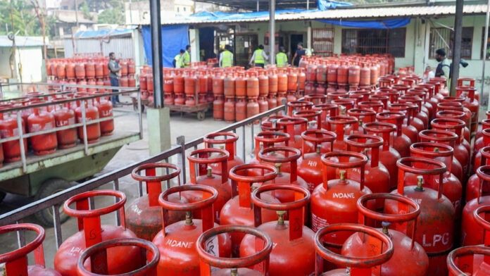 LPG cylinder price hike in India March 2026 domestic cooking gas cylinder and commercial LPG cylinders stacked at distribution center