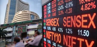 Electronic display board showing Sensex and Nifty falling sharply during a stock market trading session in India.