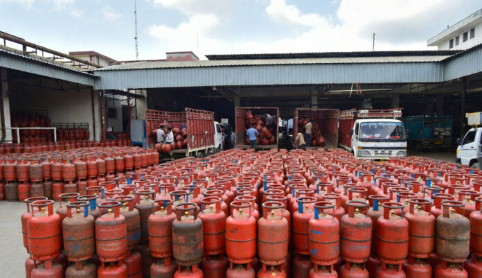 LPG-Supply-India-2026-Fuel- LPG gas cylinders stacked at distribution center in India with delivery staff preparing for supply