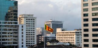 Colombo skyline with government buildings and Sri Lankan flag representing economic policy decision