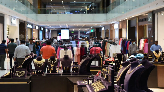 India Consumer Sector Growth and Margin Pressure 2026 Indian shopping mall with apparel stores and jewelry outlets showing strong consumer demand amid rising costs