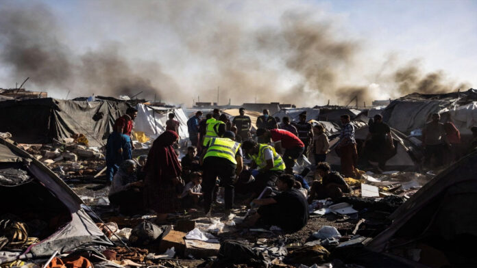 Israeli Airstrike Hits Tent Camp in Southern Gaza Displaced Palestinian families inspect damage after an Israeli airstrike in southern Gaza