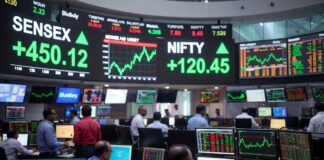 Traders watch market screens as Sensex opens at 77,358 and Nifty at 24,126 during Thursday’s positive stock market opening in Mumbai.