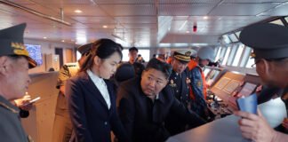 North Korean leader Kim Jong Un inspecting the Kang Kon destroyer during sea trials as military officials accompany him.